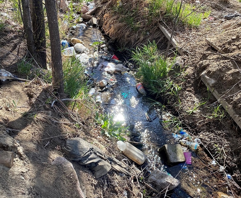Litter in a homeless camp waterway feeding into Spring Creek