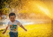 Kid Playing in Sprinkler