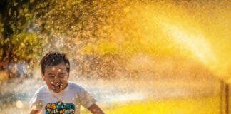 Kid Playing in Sprinkler