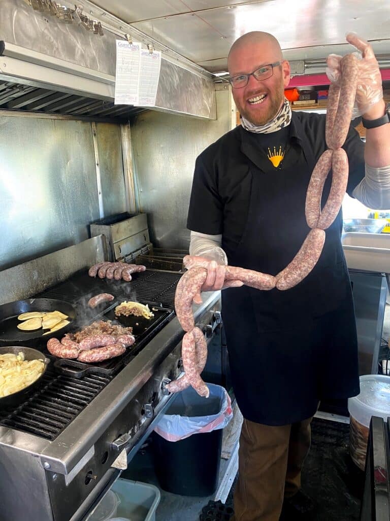 Nick holding raw sausage in Solsage Food Truck
