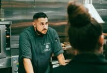Executive Chef Roberto Reyes listening to a staff member in the kitchen