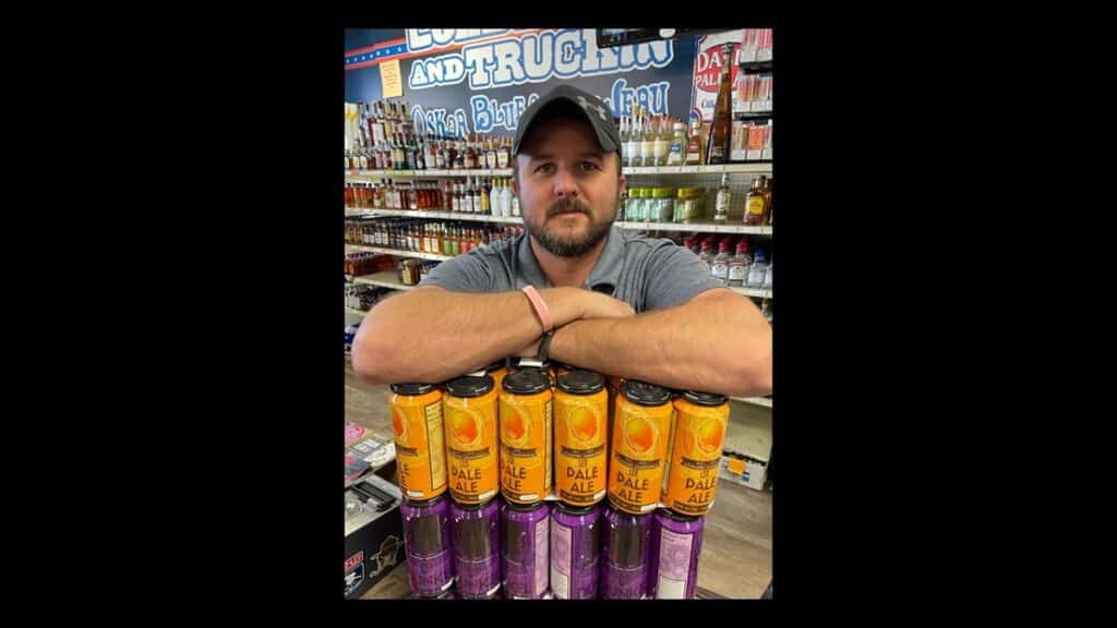 Owner Brent Baldwin of Veterans Wine & Liquor in Colorado Springs holding some product from local brewer Bell Brothers Brewing.