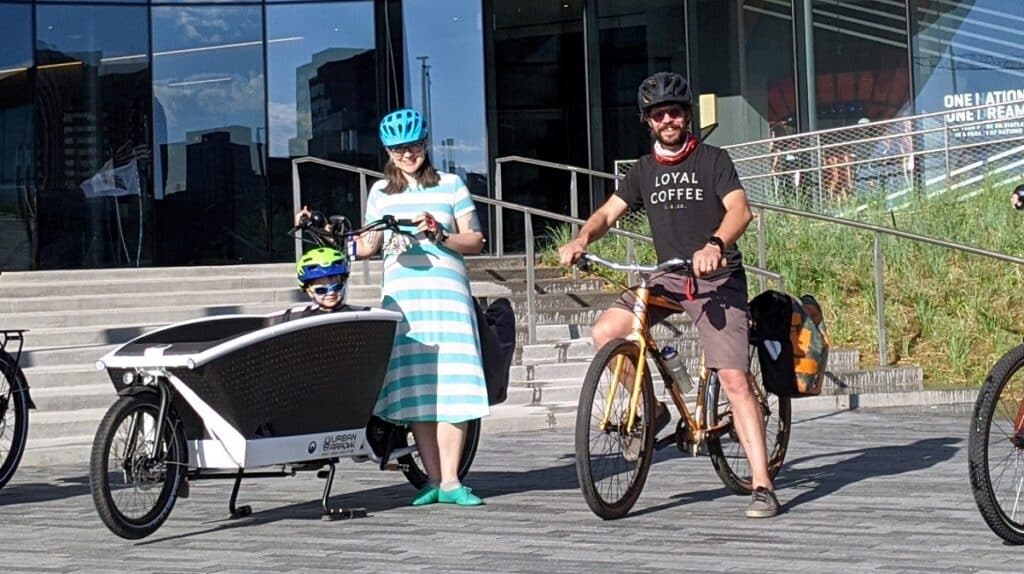 Westside Cully Radvillas, Executive Director of the Organization Of Westside Neighbors, along with his wife Hailey and son Quinn in front of the Olympic Museum.
